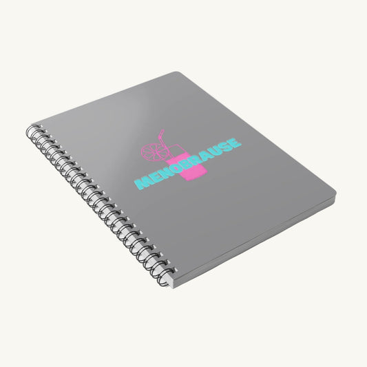 Graues A5 Spiralnotizbuch mit der Aufschrift 'MENOBRAUSE' in blauer Schrift und einer pinken Illustration eines Erfrischungsgetränks mit Strohhalm und Zitrone. Lustiges Journal-Design für Frauen in den Wechseljahren