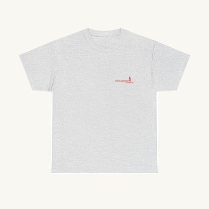 Graues T-Shirt aus Baumwolle mit einem kleinen roten Aufdruck auf der linken Brust. Das Motiv zeigt eine Surferin auf einem Board und den Schriftzug 'HITZEWELLENREITERIN' in moderner, sportlicher Schrift."