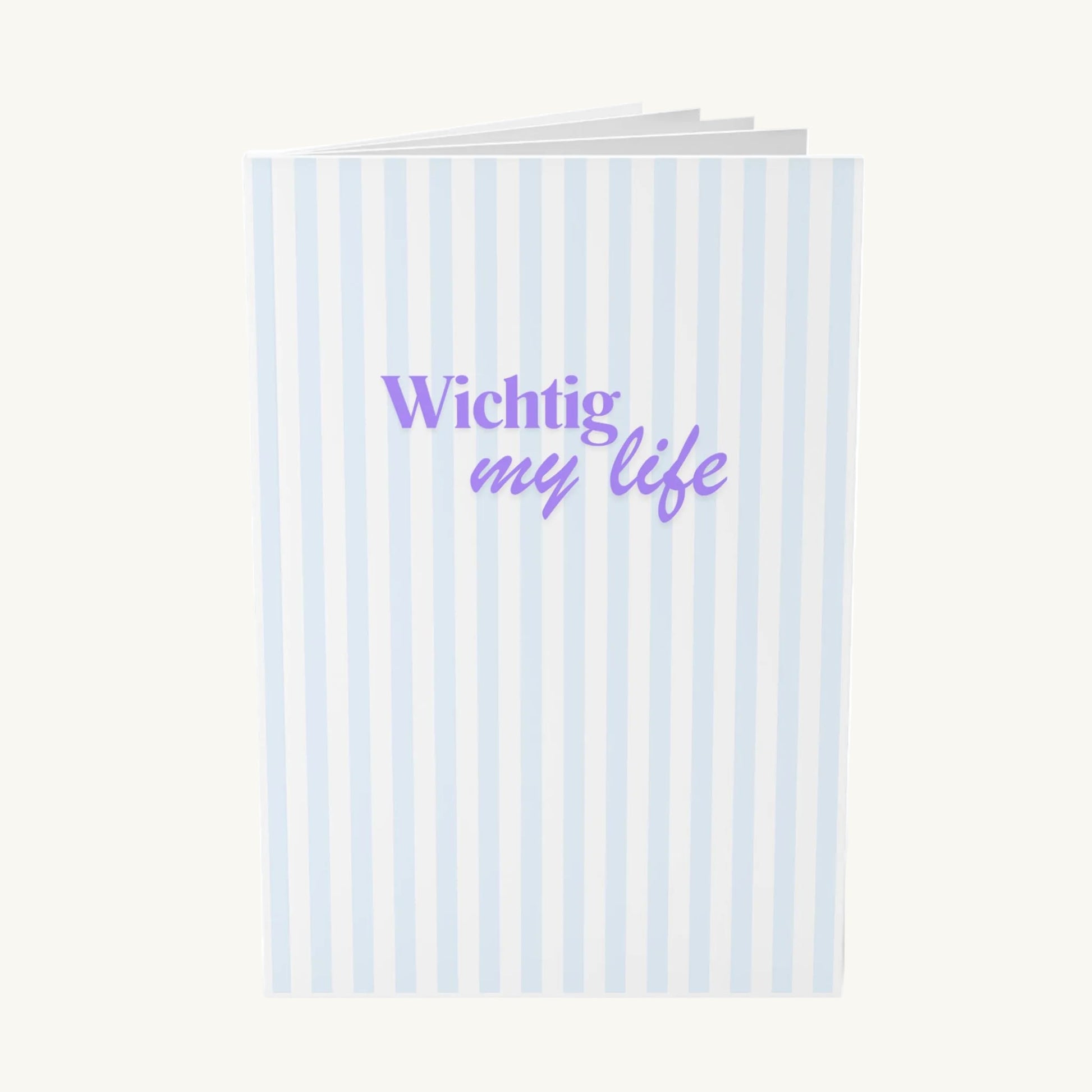 Stillvolles Notizbuch mit vertikalen hellblauen Streifen und dem modernen lila Schriftzug „Wichtig my life“ in einer Kombination aus Serifenschrift und Schreibschrift, ideal für Achtsamkeit in den Wechseljahren.