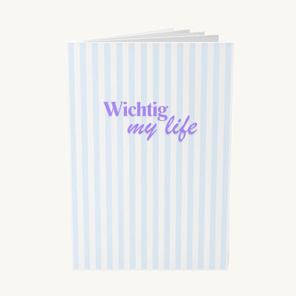 Stillvolles Notizbuch mit vertikalen hellblauen Streifen und dem modernen lila Schriftzug „Wichtig my life“ in einer Kombination aus Serifenschrift und Schreibschrift, ideal für Achtsamkeit in den Wechseljahren.