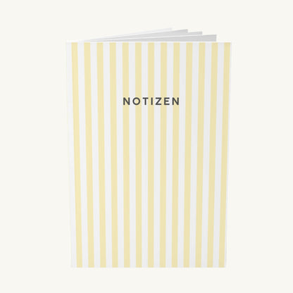  Modernes Notizbuch mit vertikalen, hellgelben Streifen und dem zentrierten, dunkelgrauen Schriftzug „NOTIZEN“ in klarer, serifenloser Schrift, ideal zur Organisation bei Brain Fog.