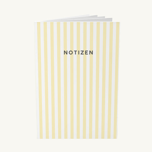  Modernes Notizbuch mit vertikalen, hellgelben Streifen und dem zentrierten, dunkelgrauen Schriftzug „NOTIZEN“ in klarer, serifenloser Schrift, ideal zur Organisation bei Brain Fog.