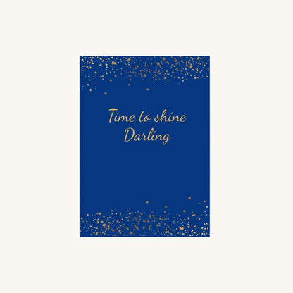 Blaues A5 Notizbuch mit der Aufschrift 'Time to shine Darling' in goldener Schrift mit kleinen goldenen Sternen für die Menopause. Das Journal ist als Begleiter für Achtsamkeit und Reflexion für Frauen in den Wechseljahren konzipiert.