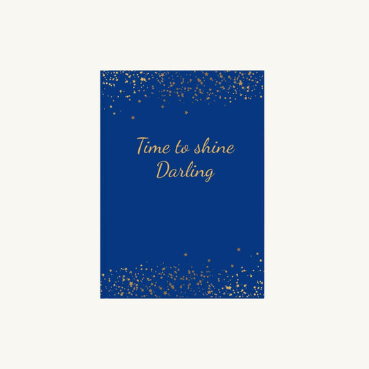 Blaues A5 Notizbuch mit der Aufschrift 'Time to shine Darling' in goldener Schrift mit kleinen goldenen Sternen für die Menopause. Das Journal ist als Begleiter für Achtsamkeit und Reflexion für Frauen in den Wechseljahren konzipiert.