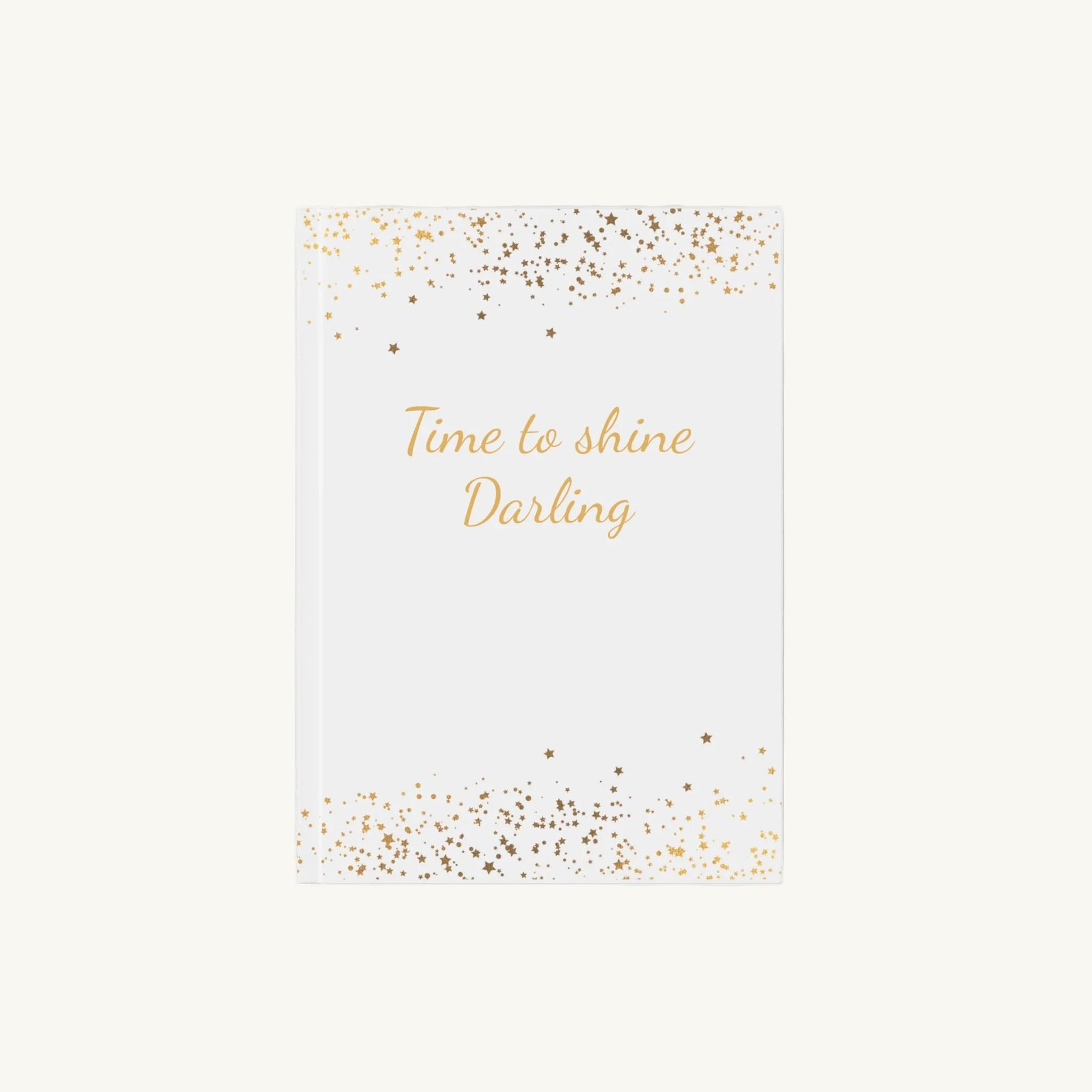 Weißes A5 Notizbuch mit der Aufschrift 'Time to shine Darling' in goldener Schrift mit kleinen goldenen Sternen für die Menopause. Das Journal ist als Begleiter für Achtsamkeit und Reflexion für Frauen in den Wechseljahren konzipiert.