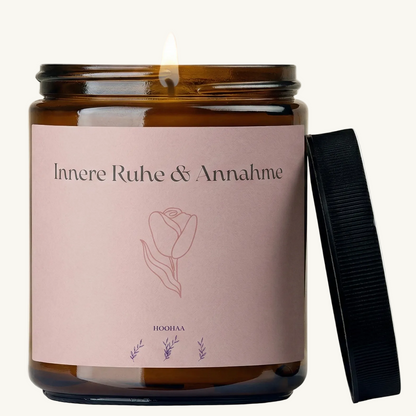 Duftkerze im braunen Apothekerglas mit brennender Flamme. Das Etikett zeigt das Design 'Innere Ruhe & Annahme' in hellem Rosa mit einer Tulpen-Illustration.