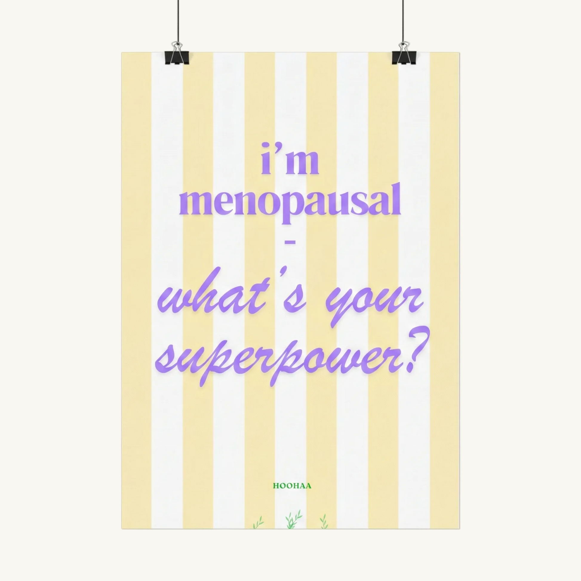 Hochformatiges Poster mit vertikalen pastellgelben und weißen Streifen. Der lila Text lautet "i'm menopausal - what's your superpower?". Am unteren Rand befindet sich der grüne Schriftzug "HOOHAA" mit kleinen pflanzlichen Illustrationen.
