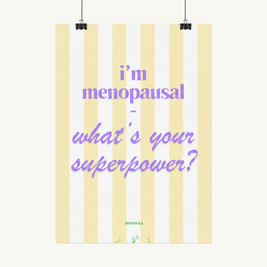 Hochformatiges Poster mit vertikalen pastellgelben und weißen Streifen. Der lila Text lautet "i'm menopausal - what's your superpower?". Am unteren Rand befindet sich der grüne Schriftzug "HOOHAA" mit kleinen pflanzlichen Illustrationen.
