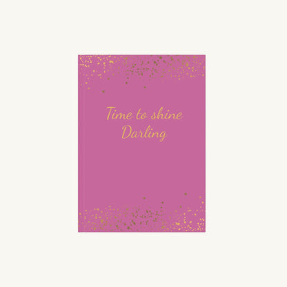 Leuchtend Rosa A5 Notizbuch mit der Aufschrift 'Time to shine Darling' in goldener Schrift mit kleinen goldenen Sternen für die Menopause. Das Journal ist als Begleiter für Achtsamkeit und Reflexion für Frauen in den Wechseljahren konzipiert.