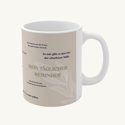 Weiße Keramiktasse mit beige-farbenem Design, Pflanzen-Illustration und deutsche 10 Affirmationen wie ‚Mein täglicher Reminder‘.“