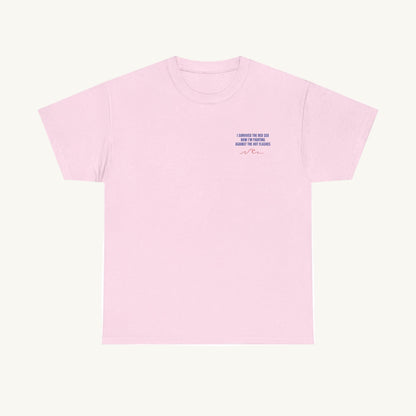Zartrosa Damen T-Shirt aus Baumwolle mit kleinem blauen Textaufdruck auf der linken Brust: 'I SURVIVED THE RED SEA NOW I'M FIGHTING AGAINST THE HOT FLASHES' ergänzt durch eine minimalistische rote Wellen-Illustration.
